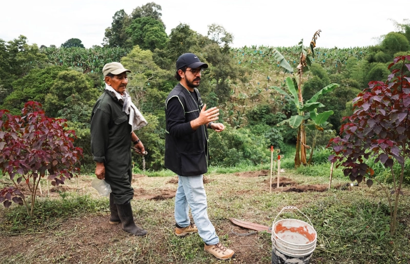 dos hombres que hacen parte del equipo de Treeoma en una plantacion para una mejor huella de carbono